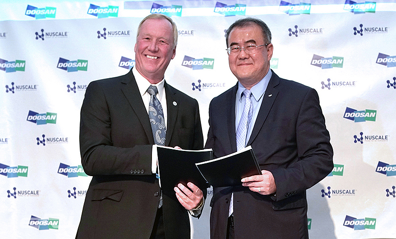 나기용 두산중공업 원자력BG장(오른쪽)과 존 홉킨스 뉴스케일파워 CEO가 MOU 체결 후 기념촬영을 하고 있다.