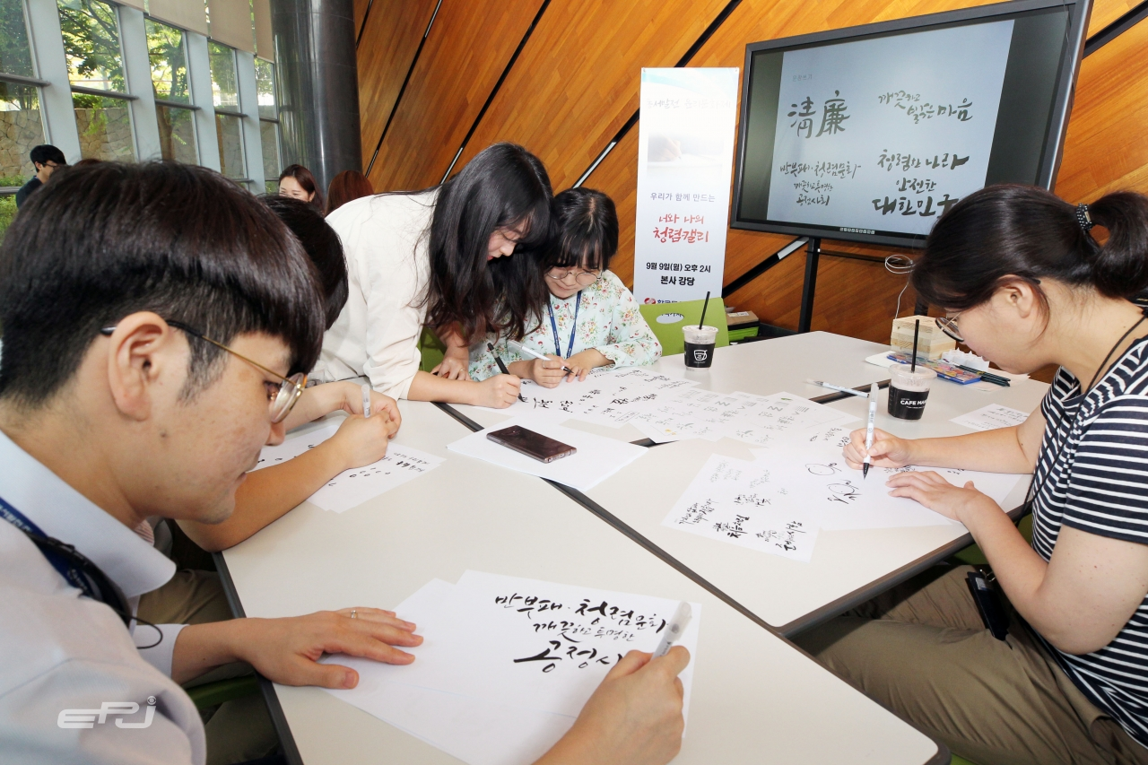 한국동서발전 직원들이 청렴 문구를 담은 캘리그라피를 작성하고 있다.