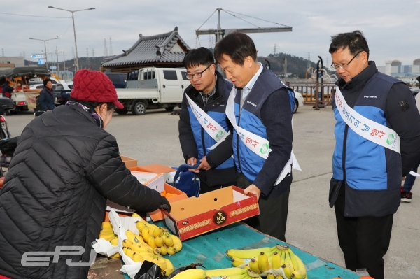 이신선 한수원 고리원자력본부장(오른쪽 두 번째)이 전통시장에서 과일을 구입하며 상인을 격려하고 있다.