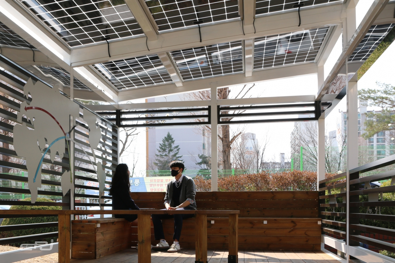 백마고등학교 학생들이 파고라 형태로 구축한 태양광 구조물 쉼터를 이용하는 모습