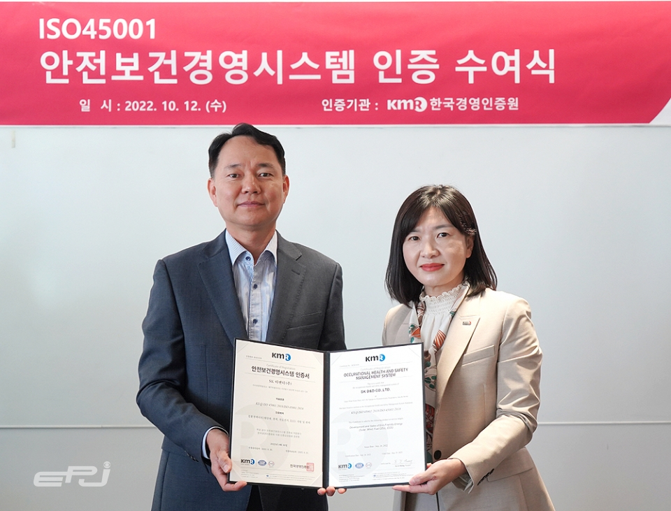 김해중 SK디앤디 에너지솔루션본부장(왼쪽)과 황은주 한국경영인증원 대표이사(오른쪽)가 ISO 45001 인증서 수여식 후 기념촬영을 하고 있다.